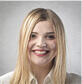 A woman with long blonde hair smiles for the camera.